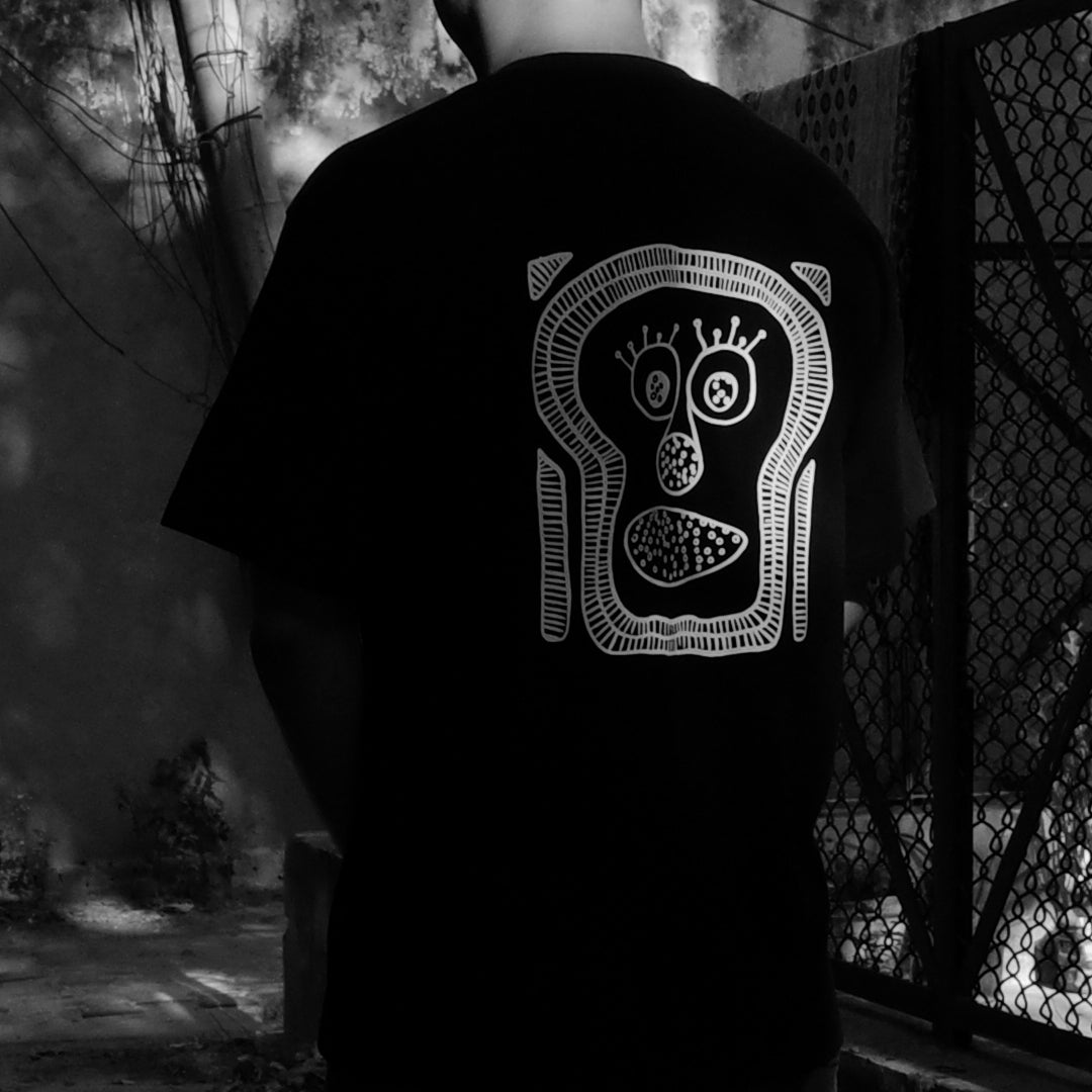 Back print of The ‘Monk’-I Man black oversized t-shirt — evolution-inspired graphic streetwear design.