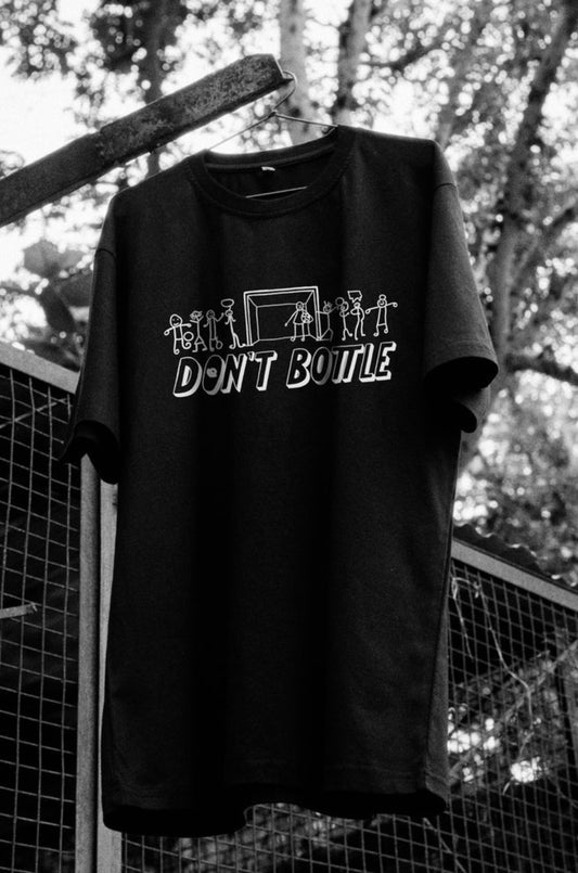 Front view of Don’t Bottle black oversized unisex t-shirt by Blaknwhite — premium cotton streetwear.