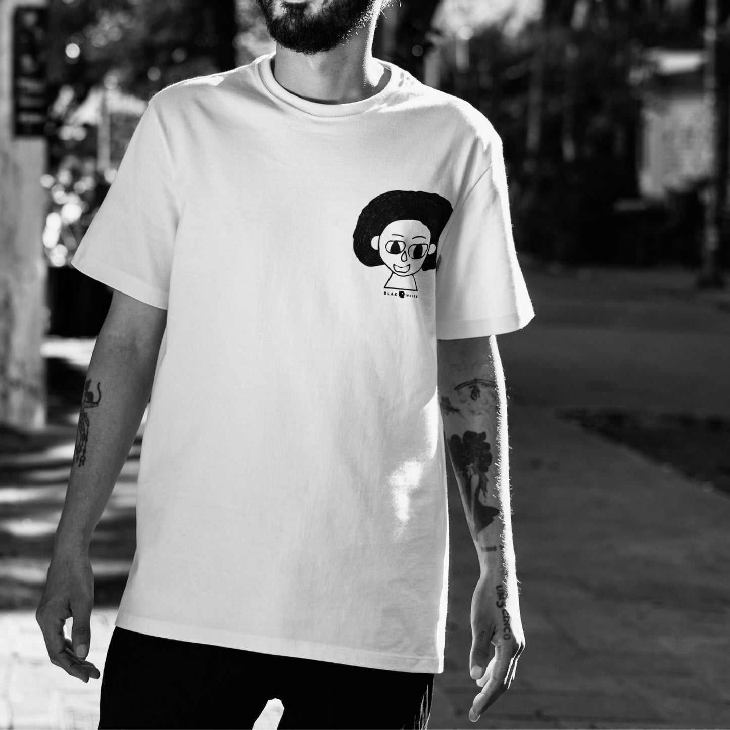 Model wearing The Artist white oversized unisex t-shirt — creative casual fashion by Blaknwhite.