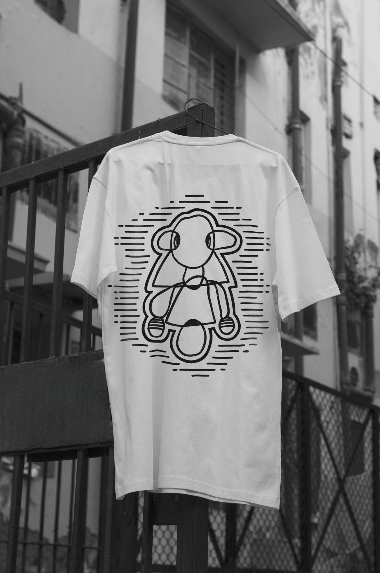 Oversized white t-shirt with a round neck and short sleeves, featuring a black and white line art design of a figure on the front.