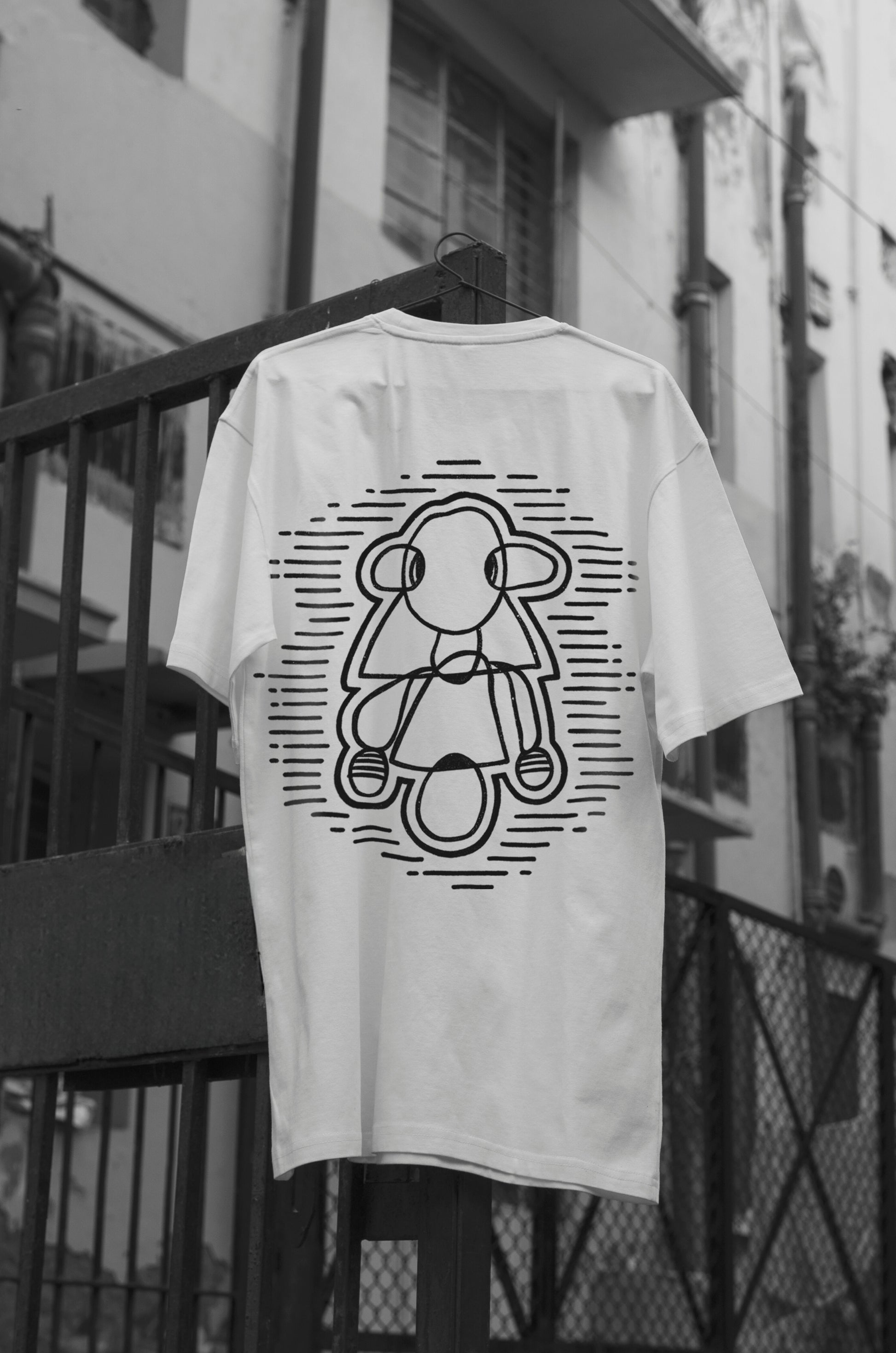 Oversized white t-shirt with a round neck and short sleeves, featuring a black and white line art design of a figure on the front.