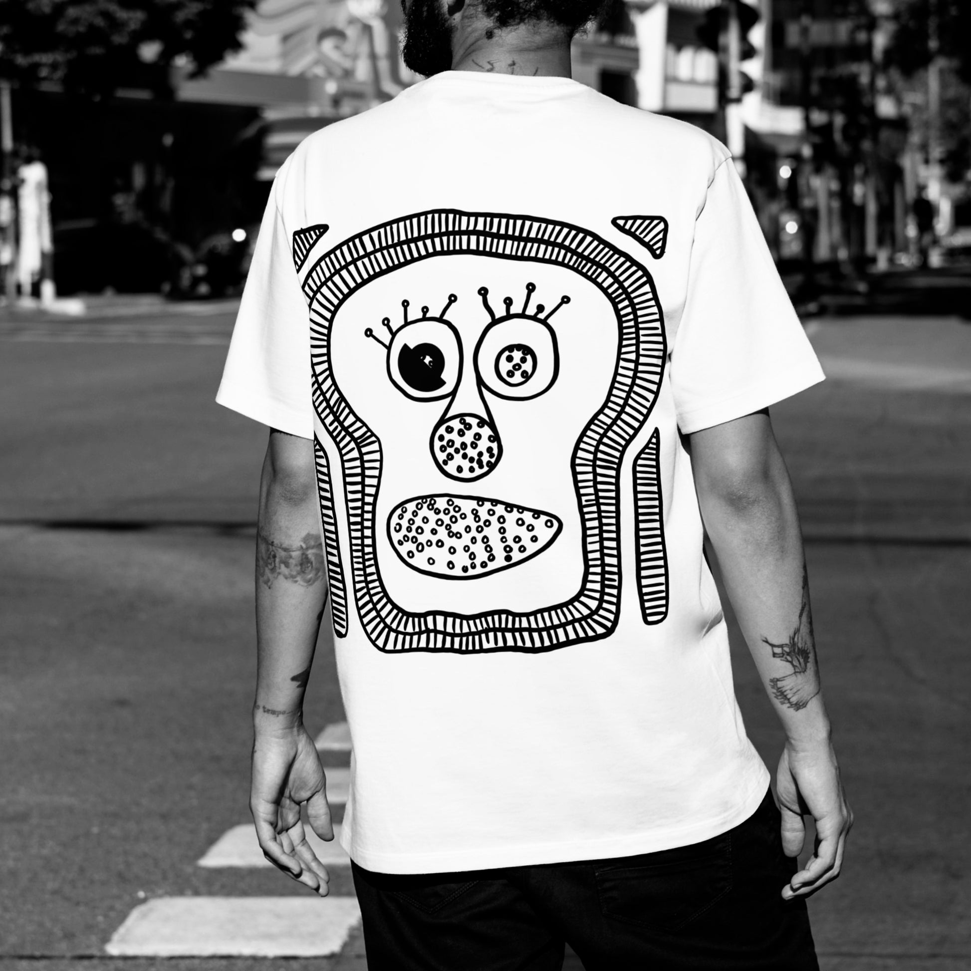 Detailed close-up of The ‘Monk’-I Man print — inspired by evolution artwork on white oversized tee.